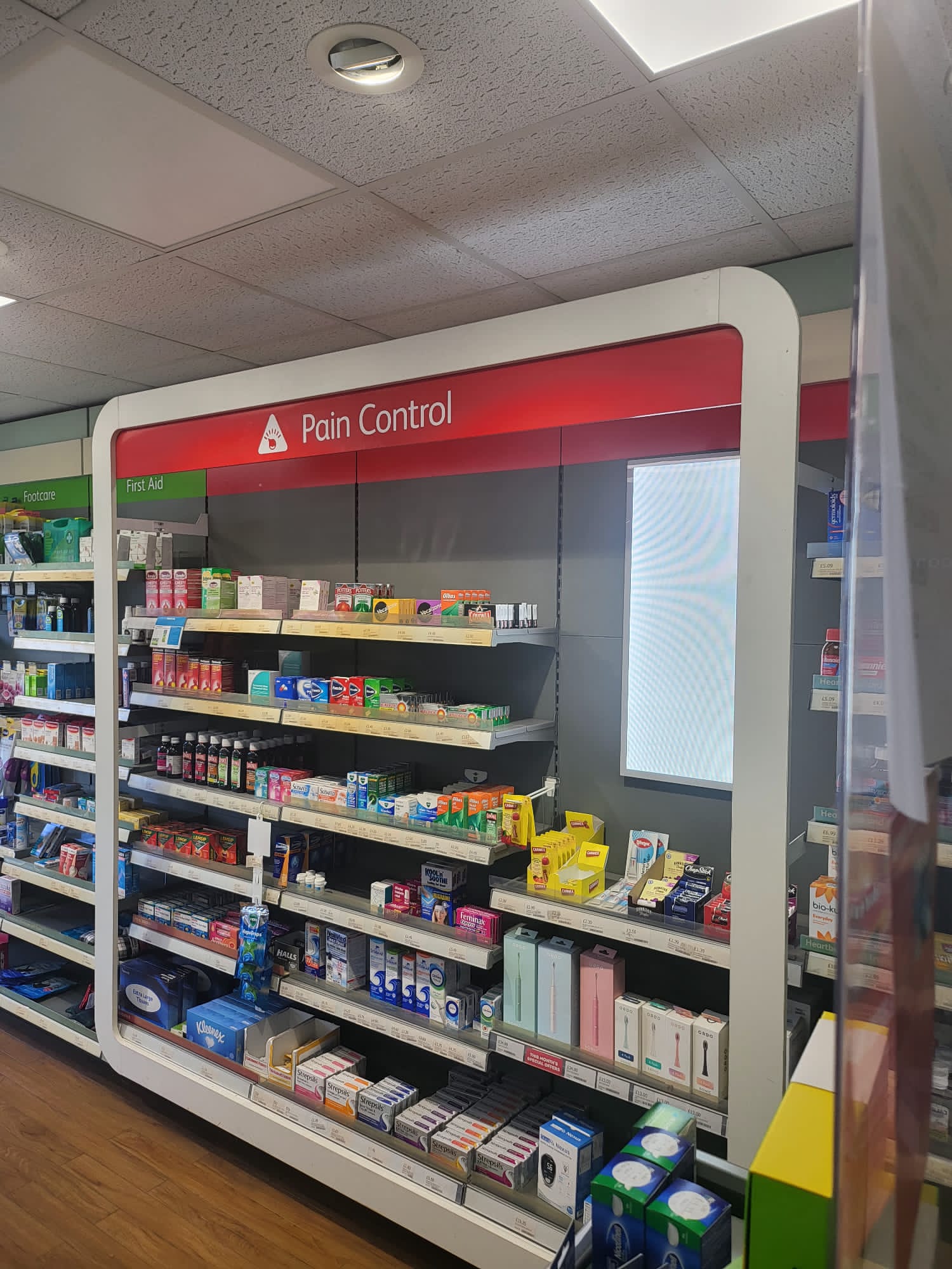Inside Midsomer Pharmacy showing all the OTC medicines displayed on the shelves
