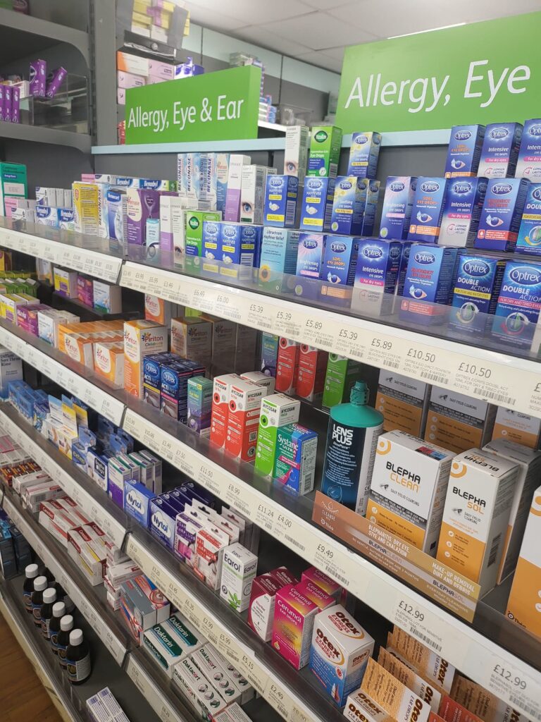 Inside Midsomer Pharmacy showing all the OTC medicines displayed on the shelves